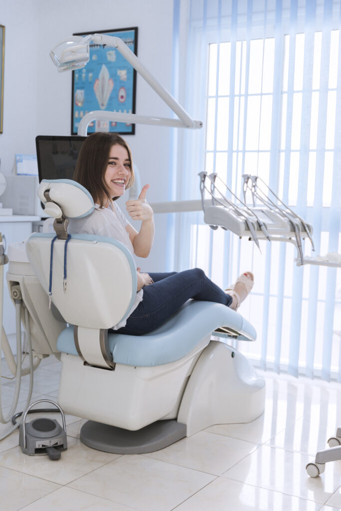 sorrindo femininas paciente sentando ligado cadeira mostrando polegar up em dental clinica sorrindo femininas paciente sentando ligado cadeira mostrando polegar up em dental clinica